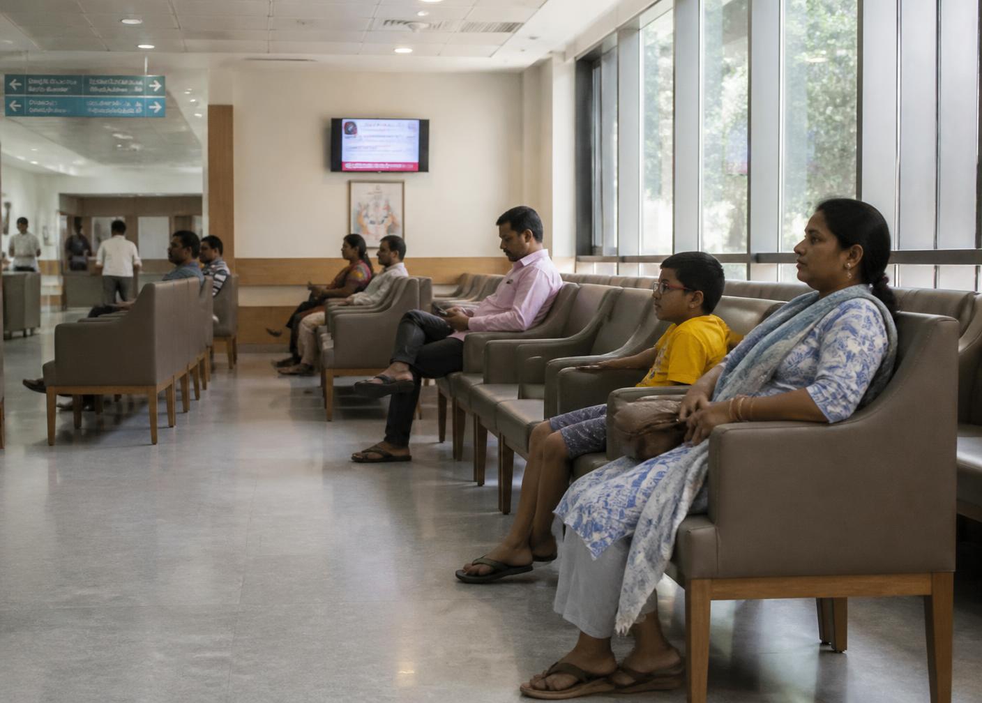 Outpatient waiting area with rows of seating and daylight from large windows